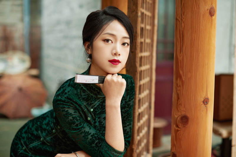 身穿旗袍在庭院散步的年轻美女图片