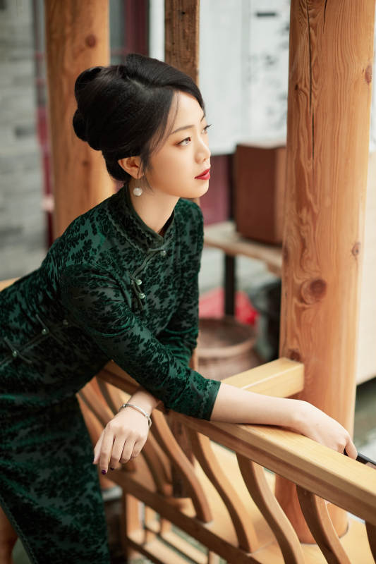 身穿旗袍在庭院散步的年轻美女图片