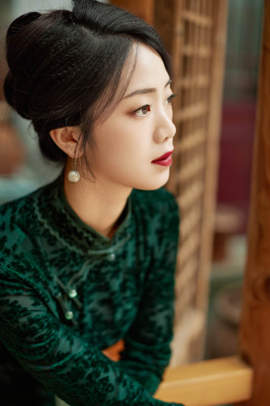 身穿旗袍在庭院散步的年轻美女图片