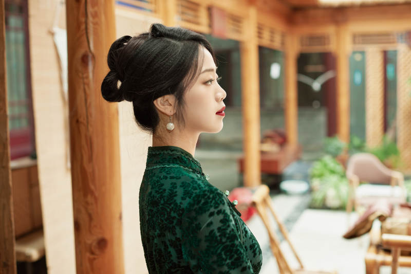 身穿旗袍在庭院散步的年轻美女图片