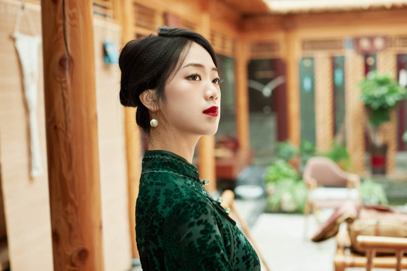 身穿旗袍在庭院散步的年轻美女图片