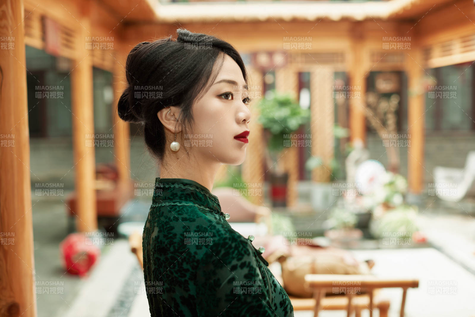 身穿旗袍在庭院散步的年轻美女图片