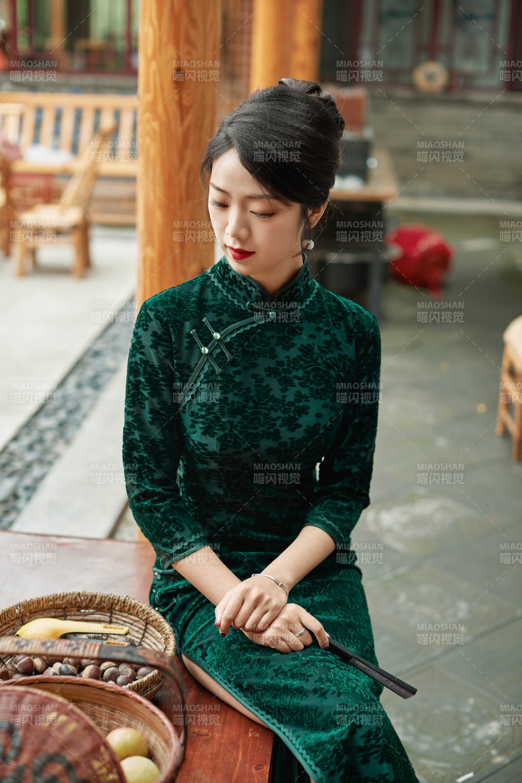 身穿旗袍在庭院散步的年轻美女图片