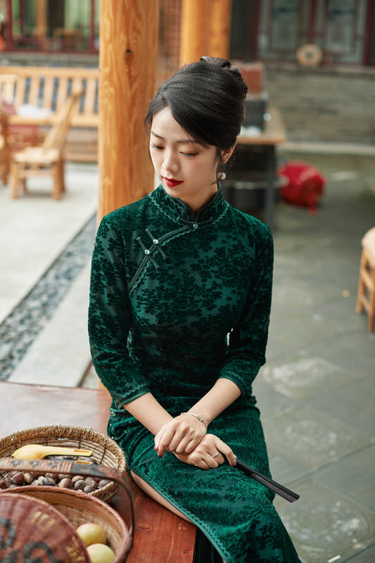 身穿旗袍在庭院散步的年轻美女图片