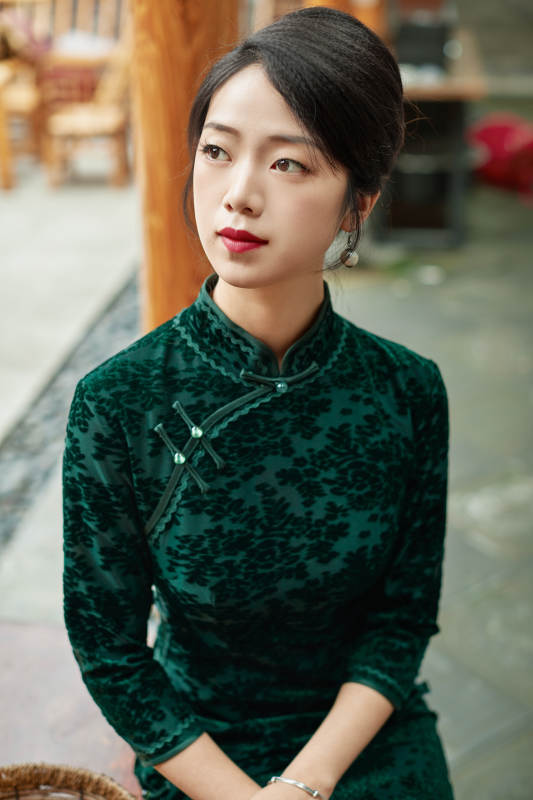 身穿旗袍在庭院散步的年轻美女图片