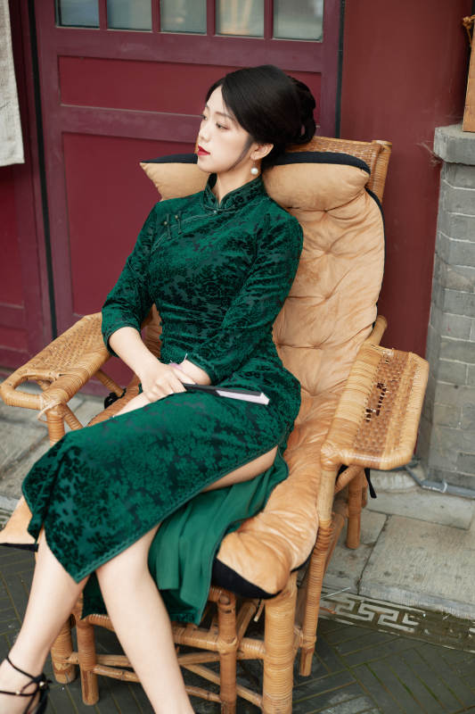 坐在中式庭院里身穿复古旗袍的亚洲女性图片