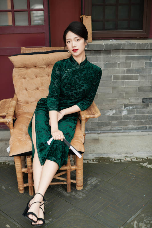 坐在中式庭院里身穿复古旗袍的亚洲女性图片