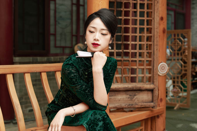 在中式庭院里身穿复古旗袍的亚洲女性图片