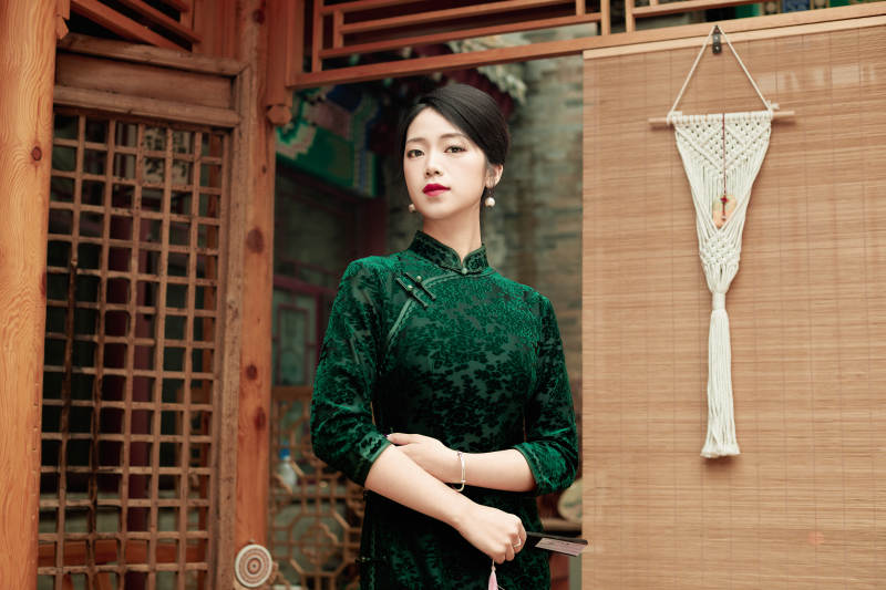 在中式庭院里身穿复古旗袍的亚洲女性图片