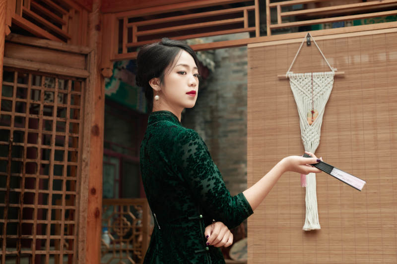 在中式庭院里身穿复古旗袍的亚洲女性图片