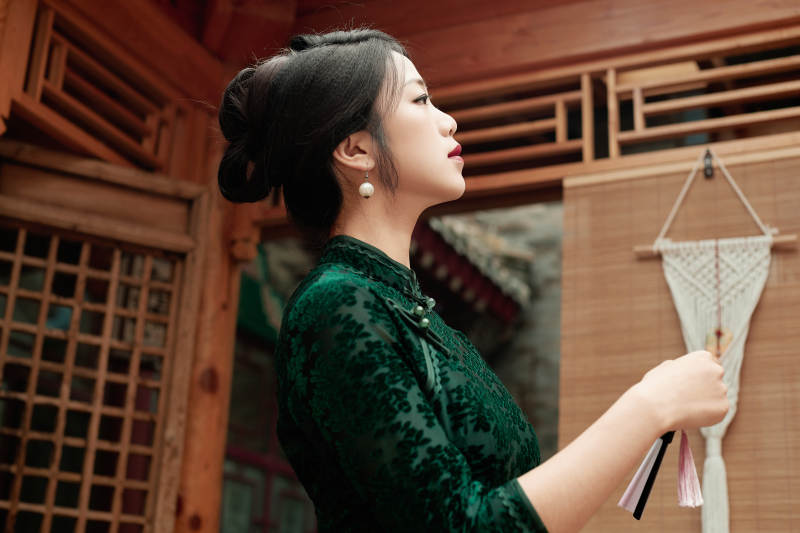 在中式庭院里身穿复古旗袍的亚洲女性图片