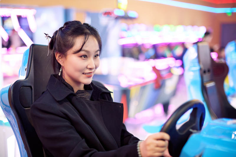 周末在电子游戏娱乐玩赛车游戏的美女图片