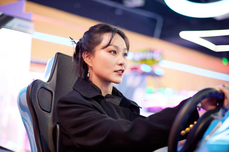 周末在电子游戏娱乐玩赛车游戏的美女图片