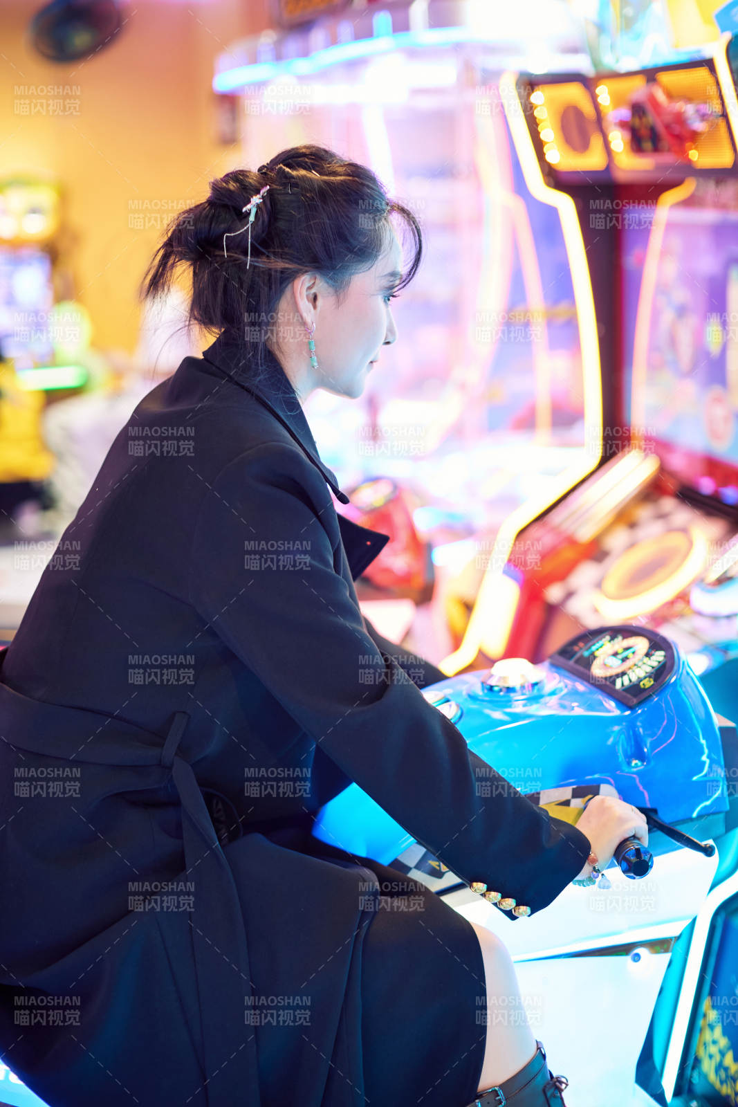 周末在电子游戏娱乐城玩摩托车游戏的美女图片