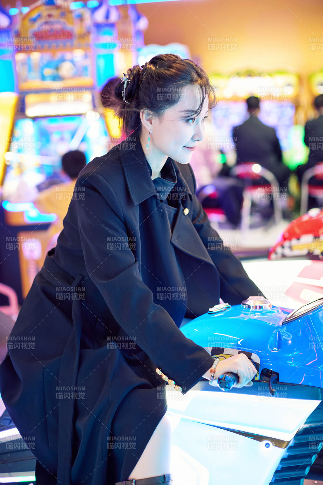 周末在电子游戏娱乐城玩摩托车游戏的美女图片