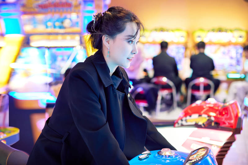 周末在电子游戏娱乐城玩摩托车游戏的美女图片