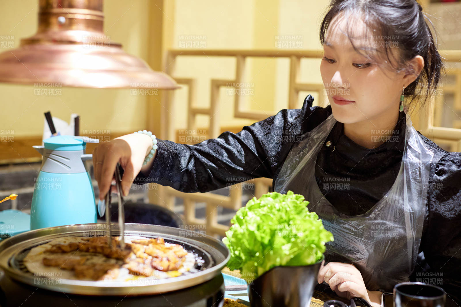 在韩式烤肉店享受美食的亚洲美女图片