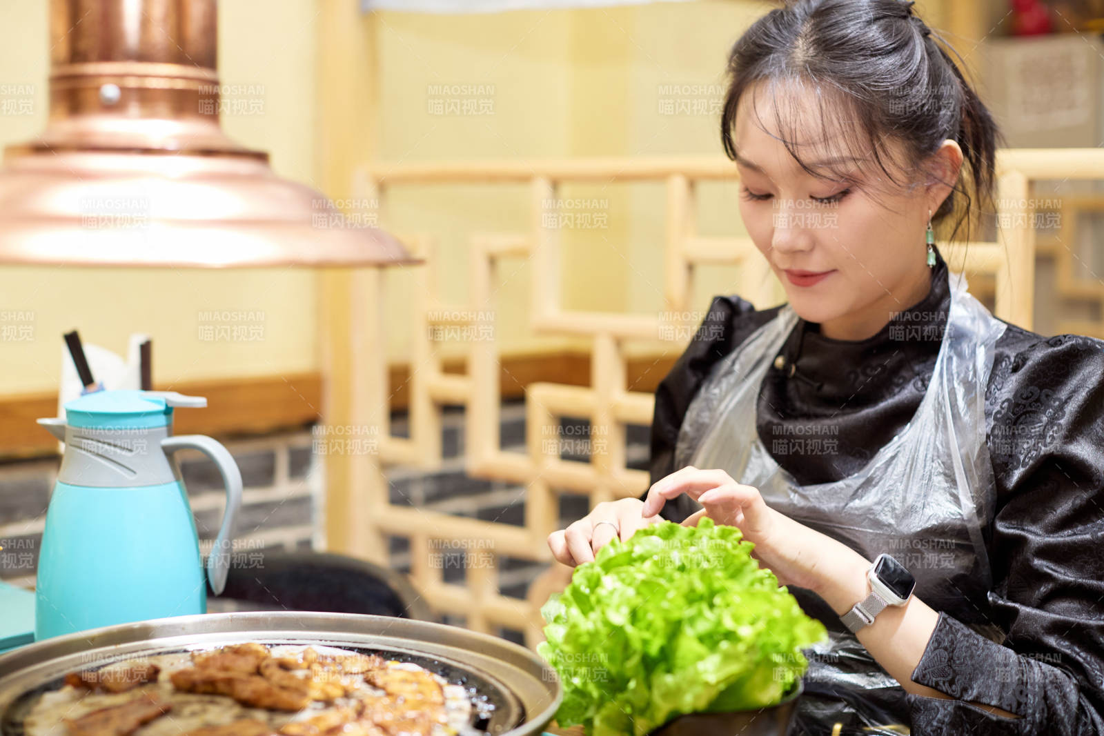 在韩式烤肉店享受美食的亚洲美女图片