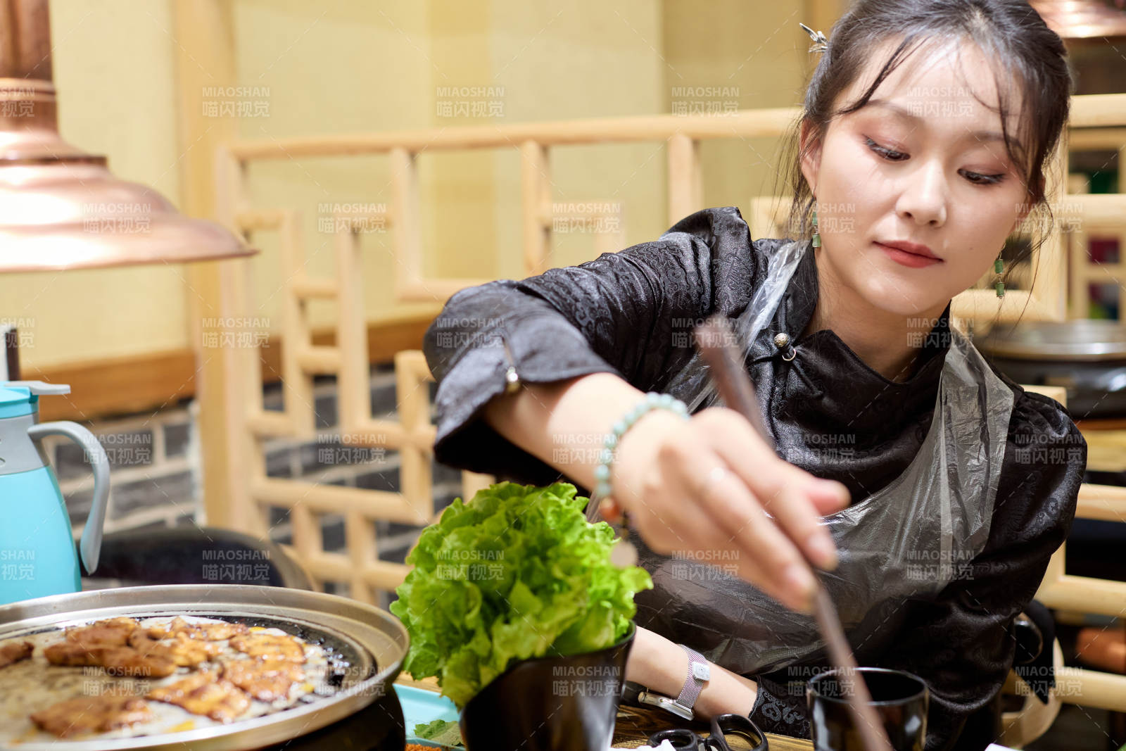 在韩式烤肉店享受美食的亚洲美女图片