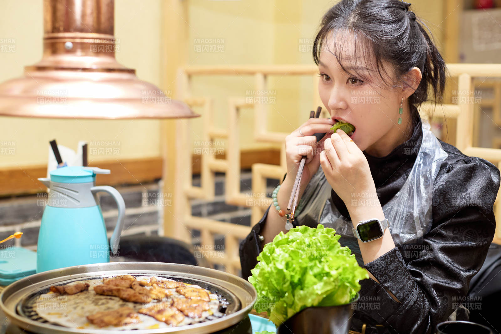 在韩式烤肉店享受美食的亚洲美女图片