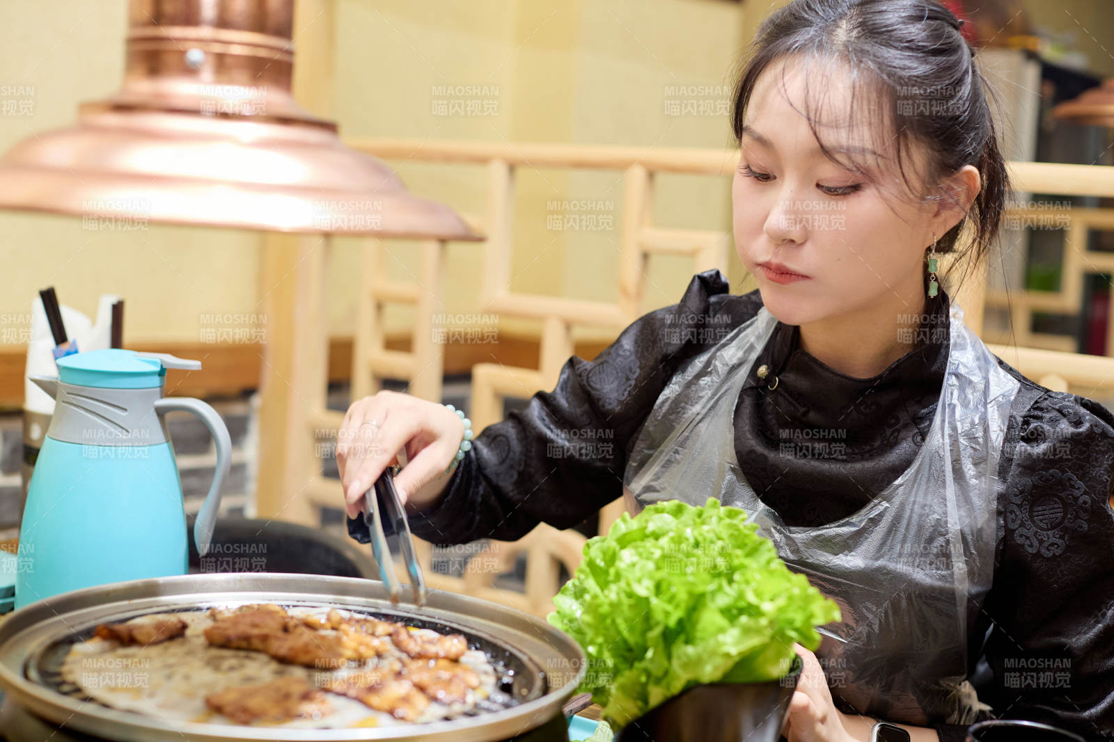 在韩式烤肉店享受美食的亚洲美女图片