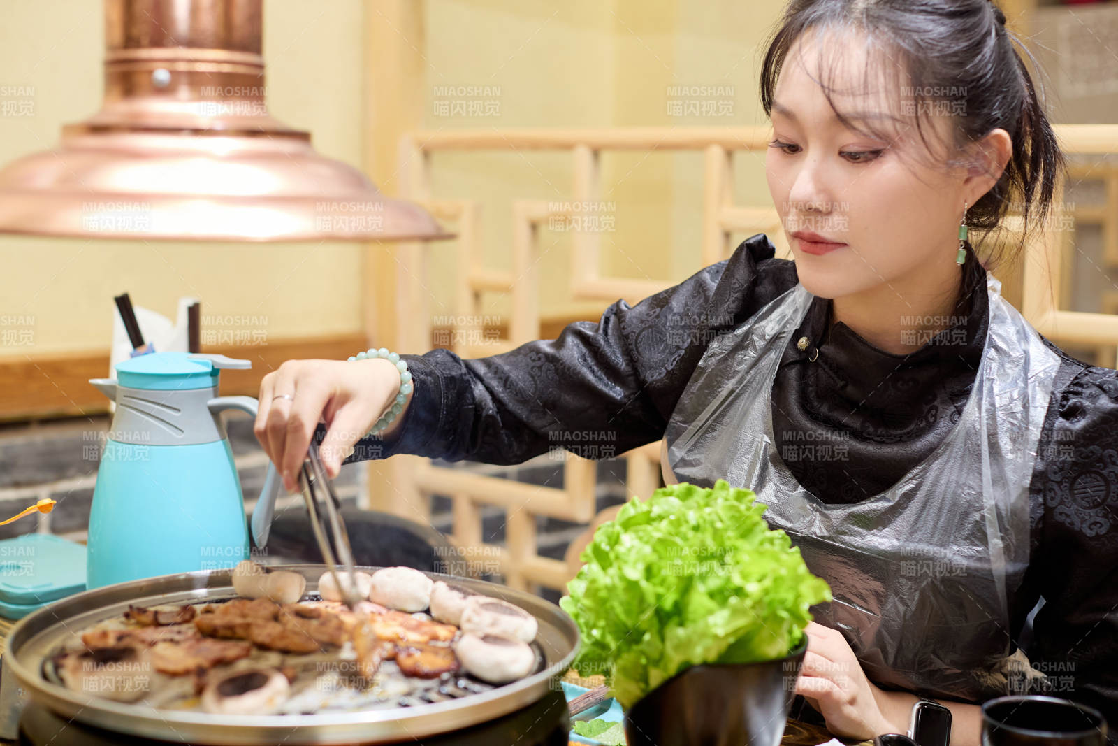 在韩式烤肉店享受美食的亚洲美女图片