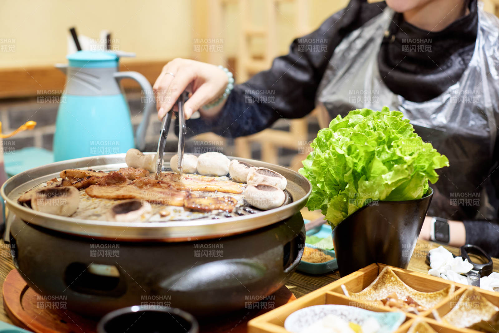 在韩式烤肉店享受美食的亚洲美女图片