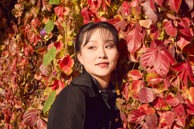 秋天在红叶遍布的河边拍照的亚洲女性图片