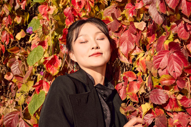 秋天在红叶遍布的河边拍照的亚洲女性图片