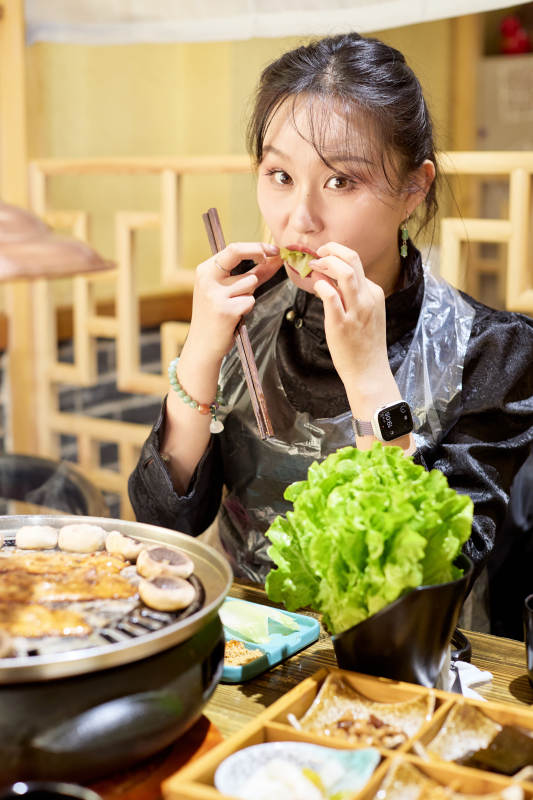 在韩式烤肉店享受美食的亚洲美女图片