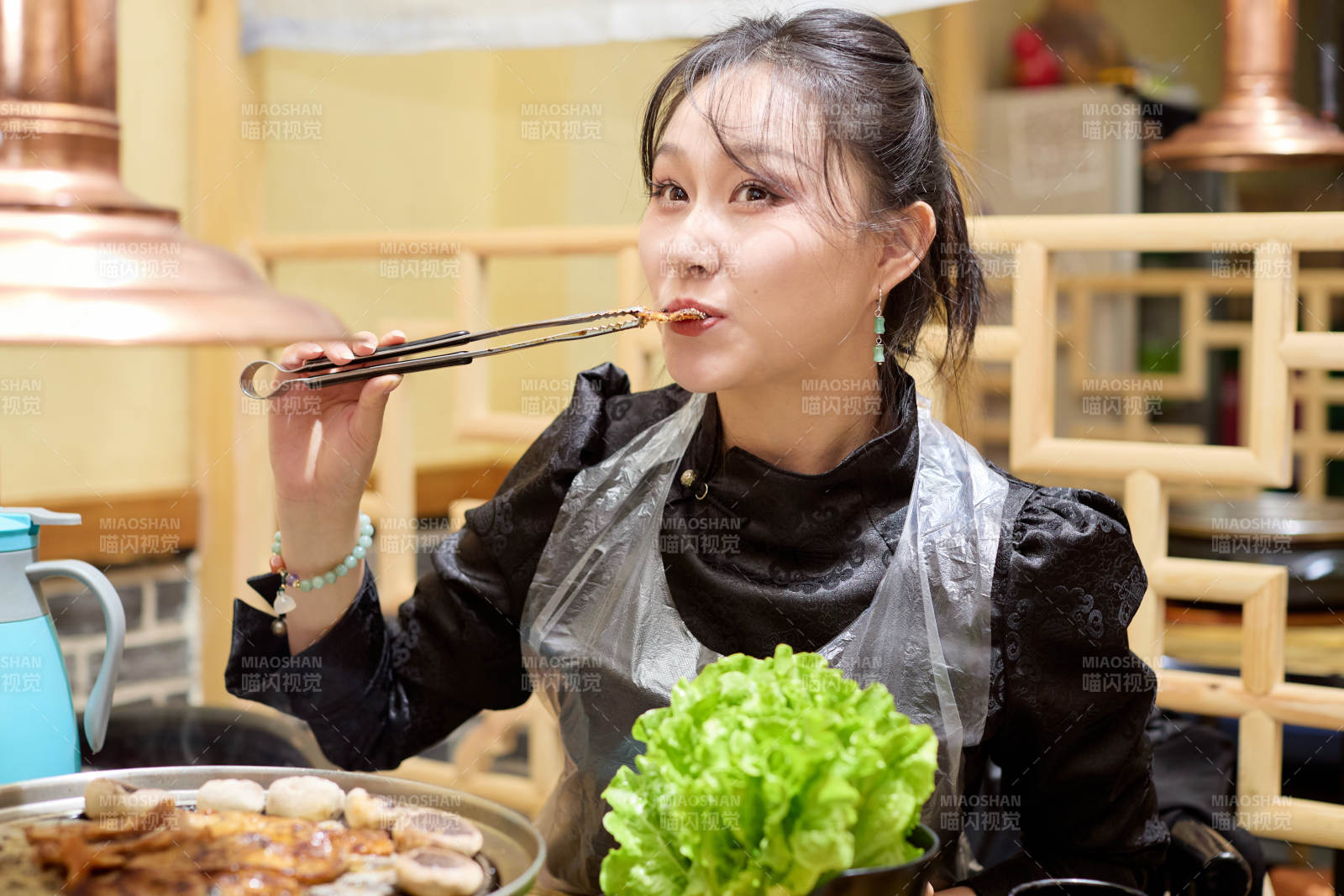 在韩式烤肉店享受美食的亚洲美女图片