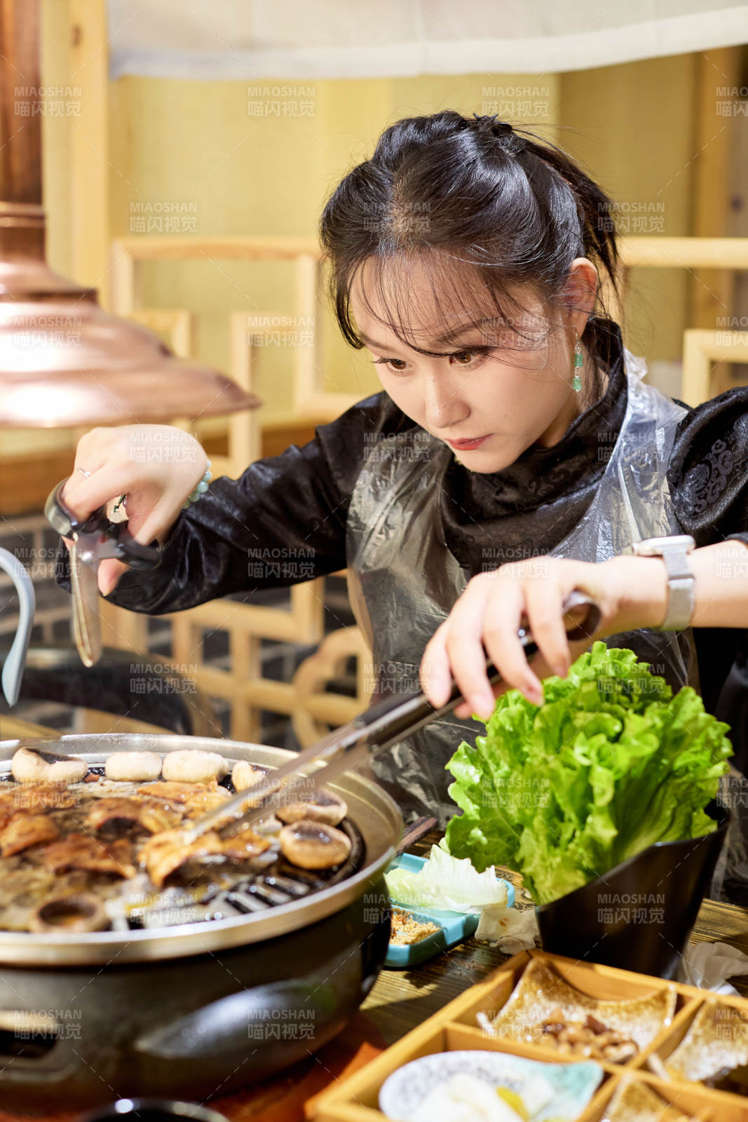 在韩式烤肉店享受美食的亚洲美女图片