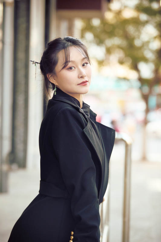 在繁华的街道上拍照的东方女性图片