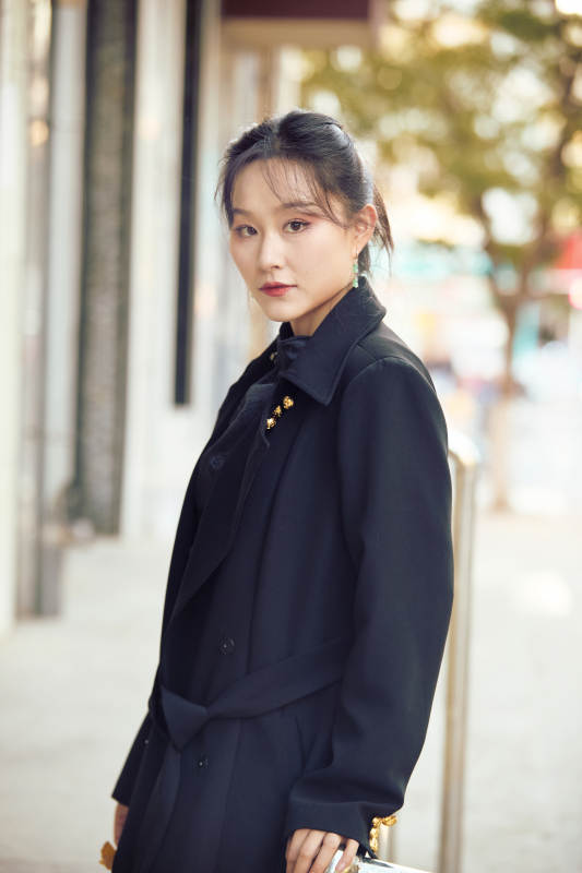 在繁华的街道上拍照的东方女性图片