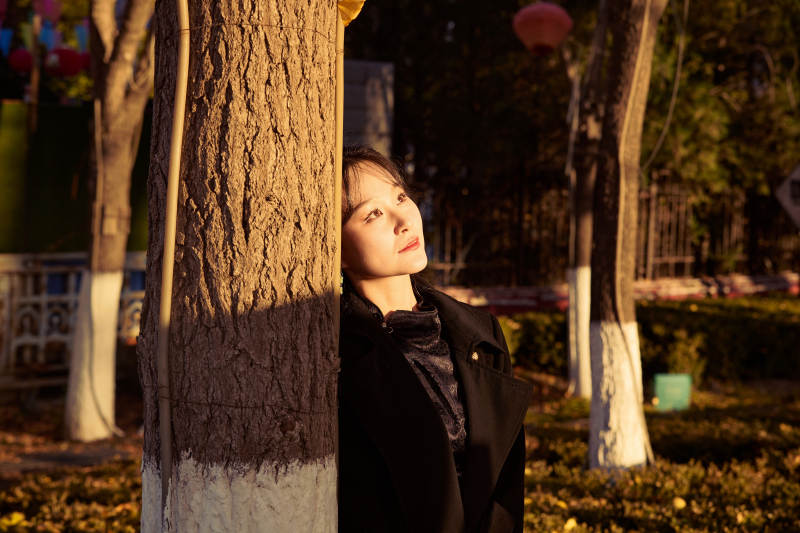 秋季午后在公园里享受阳光的东方美女图片