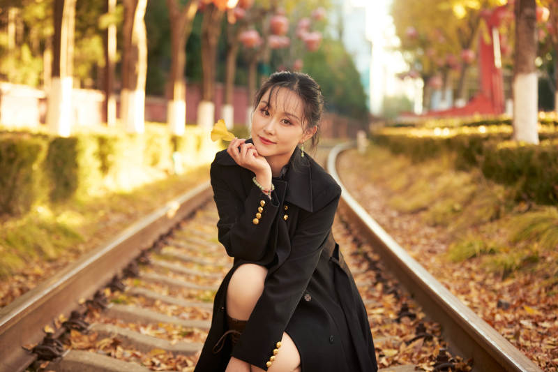 深秋午后在废弃铁轨上拍照的亚洲美女图片