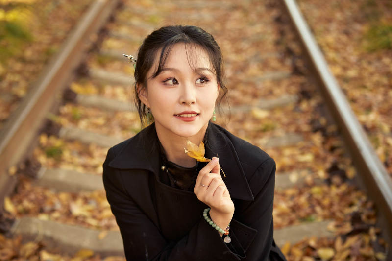 深秋午后在废弃铁轨上拍照的亚洲美女图片