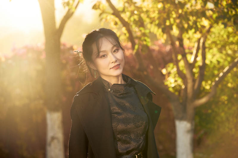 阳光明媚的午后在公园树林拍照的美女图片
