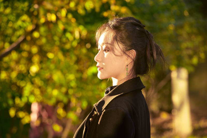 阳光明媚的午后在公园树林拍照的美女图片