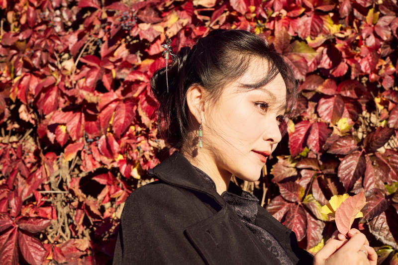 秋天在红叶遍布的河边拍照的亚洲女性图片