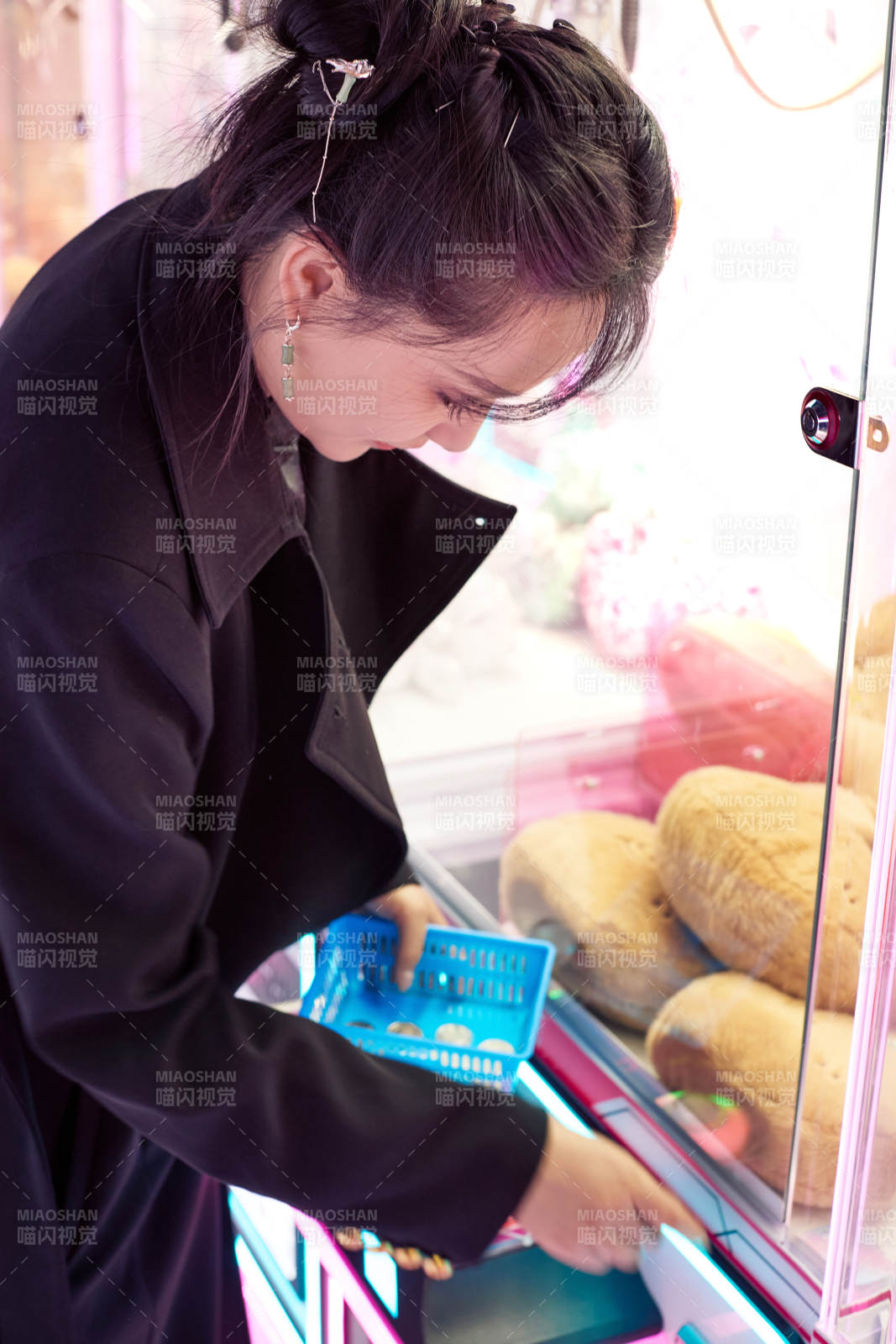 在娱乐城玩抓娃娃机的美女图片