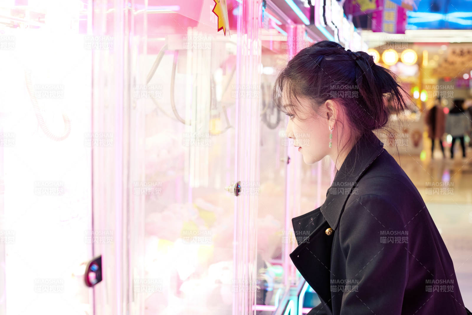 在娱乐城玩抓娃娃机的美女图片