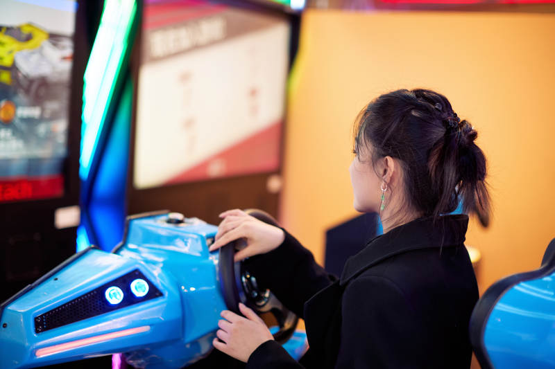 周末在电子游戏娱乐玩赛车游戏的美女图片