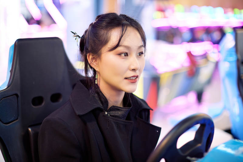 周末在电子游戏娱乐玩赛车游戏的美女图片