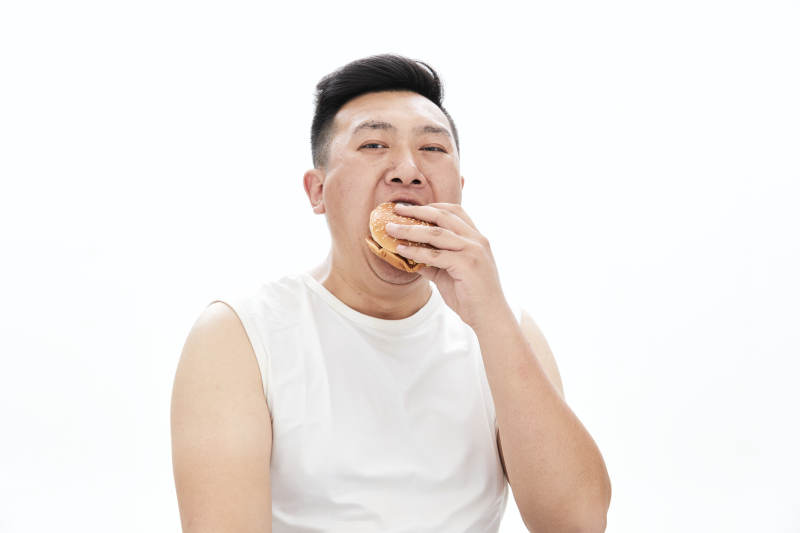 大吃特吃各种食物的肥胖亚洲男子图片