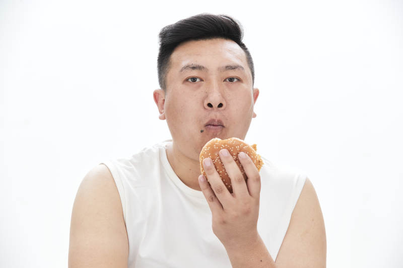 大吃特吃各种食物的肥胖亚洲男子图片