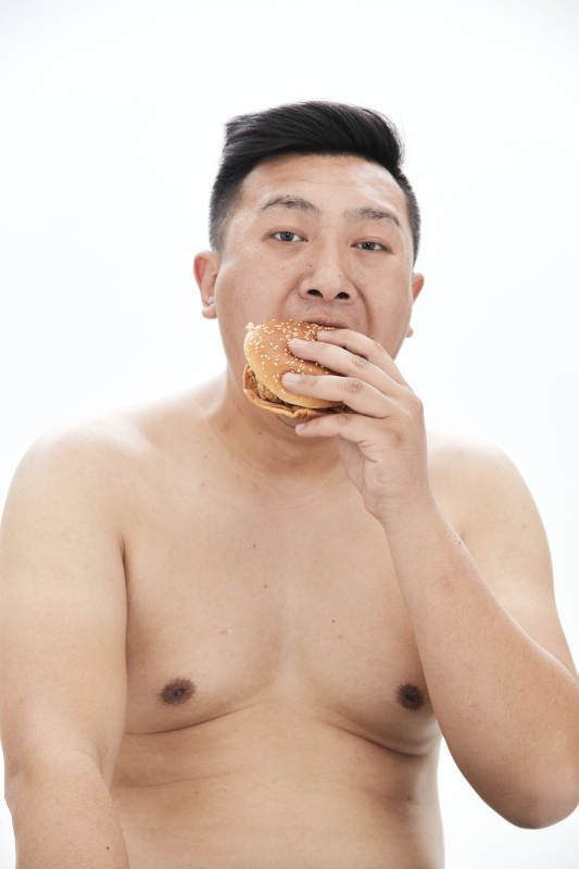大吃特吃各种食物的肥胖亚洲男子图片