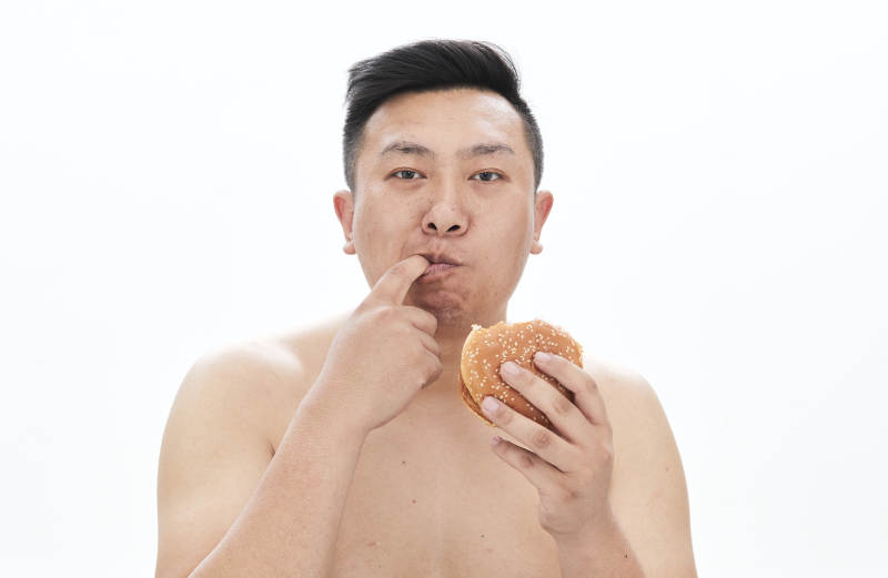 大吃特吃各种食物的肥胖亚洲男子图片