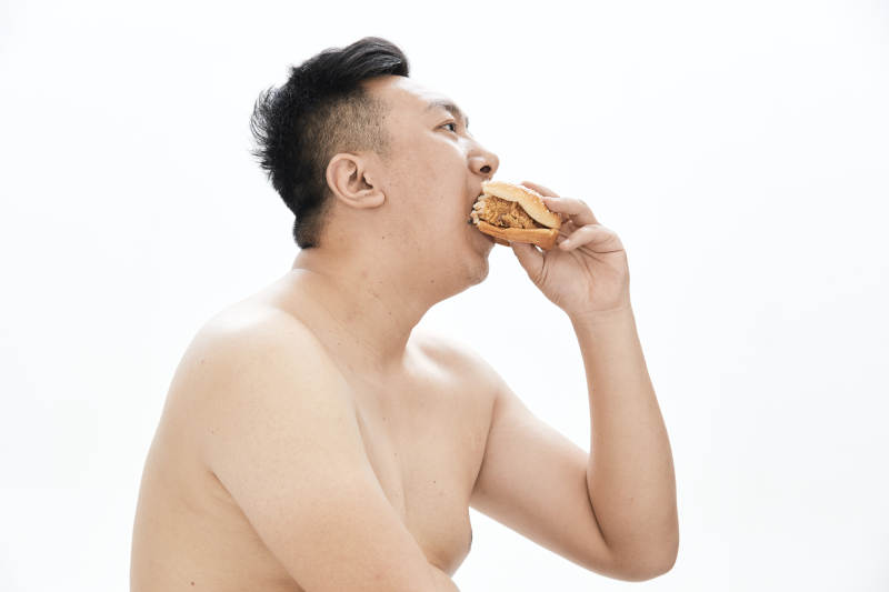 大吃特吃各种食物的肥胖亚洲男子图片