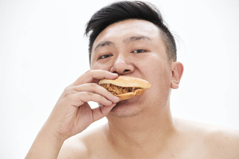 大吃特吃各种食物的肥胖亚洲男子图片